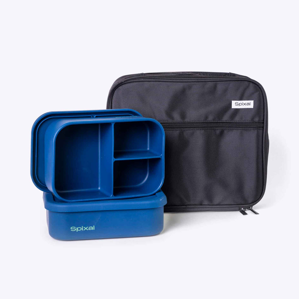 Blue silicone lunch bento box with compartments and a black carrying lunch bag on a white background