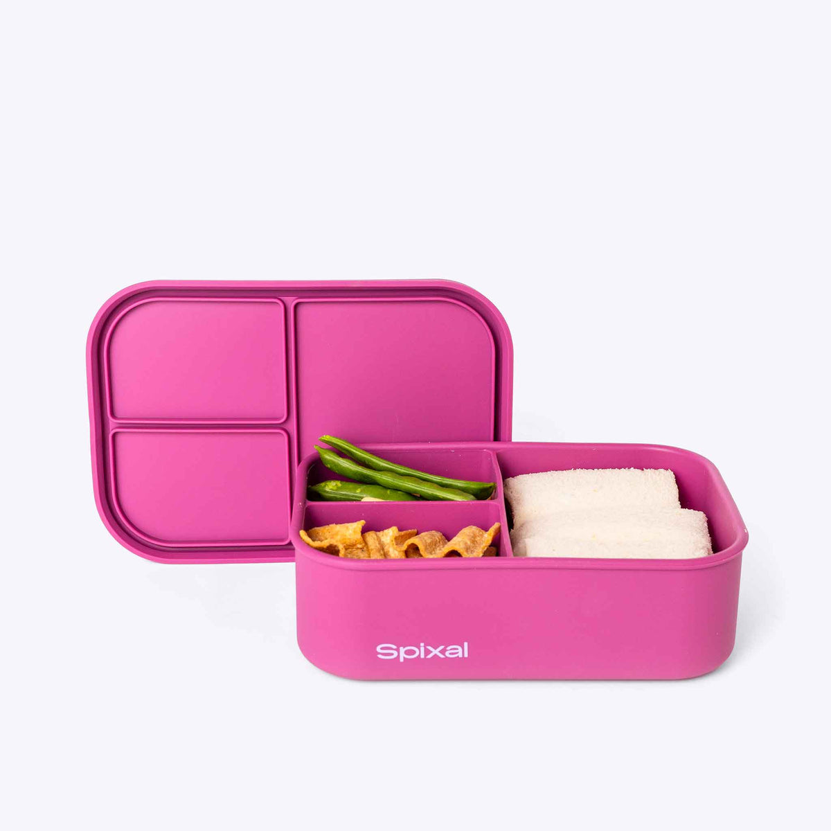 Pink bento box with compartments containing snacks on a white background