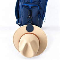 Navy blue magnetic hat clip holding a school hat on a kids school bag | Spixal