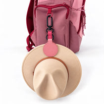 Pink magnetic hat clip holding a school hat on a girls school backpack | Spixal