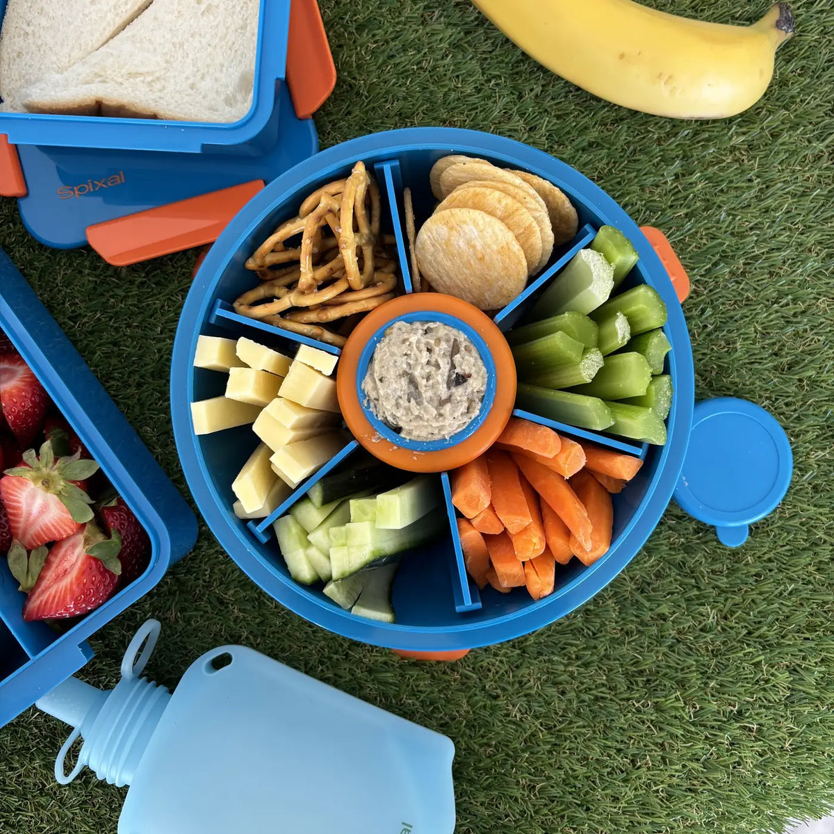 Blue Roundie bento with snacks next to a blue lunch box and banana