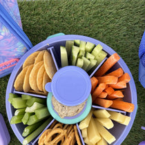 Purple Roundie bento lunch box packed with crackers, veggies, pretzels and dip