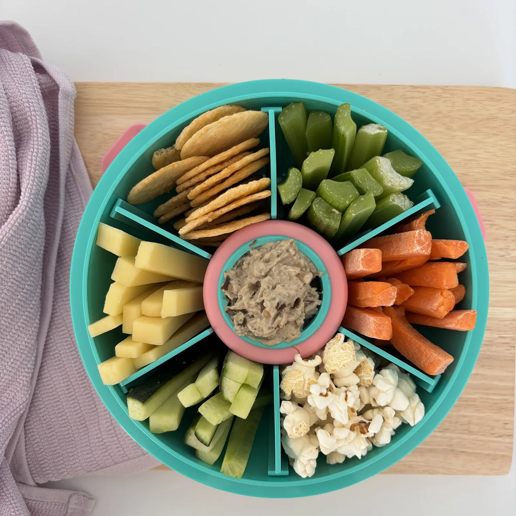 Teal Roundie bento lunch box packed with crackers, veggie sticks and a dip pot