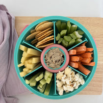 Teal Roundie bento lunch box packed with crackers, veggie sticks and a dip pot